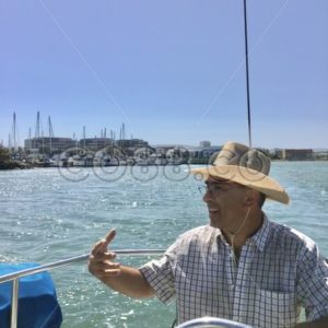 Man on the Helm of his Sailboat enjoying an Outing in the San Francisco Bay on a clear and sunny Day - CO88.co