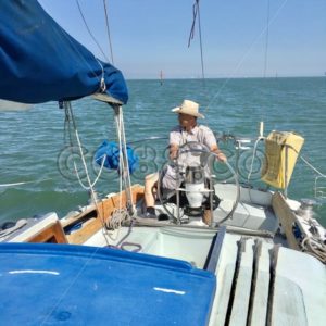 A Man (the Captain) sitting on Helm of Sailboat steering his Vessel through San Francisco Bay Waters - CO88.co