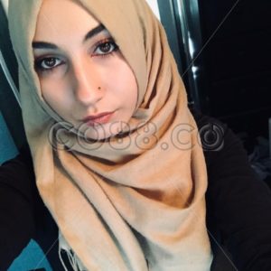 An Attractive Young Muslim Woman wearing a Traditional Beige Hijab and a Modern Black Abaya - CO88.co